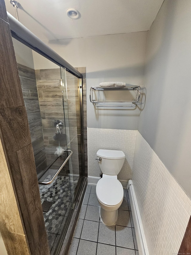 58 Waverly Pl, Bridgeport, CT 06610 - full bathroom featuring tile patterned flooring, toilet, a shower stall, a wainscoted wall, and tile walls