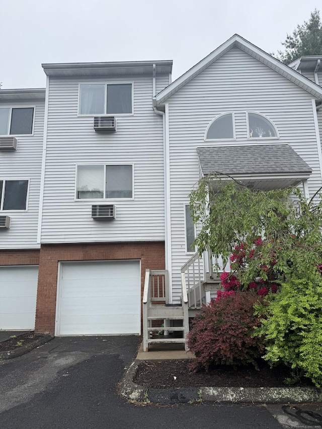 925 Oronoke Rd Unit 12G, Waterbury, CT 06708 - view of front facade with a garage, asphalt driveway, brick siding, and cooling unit