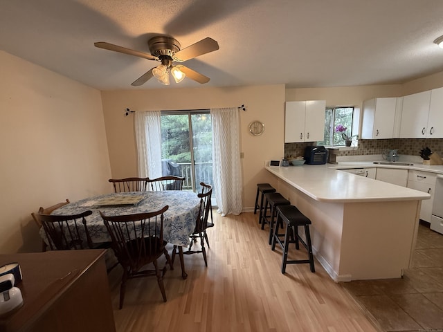 925 Oronoke Rd Unit 12G, Waterbury, CT 06708 - kitchen featuring healthy amount of natural light, a peninsula, a breakfast bar, and white cabinetry