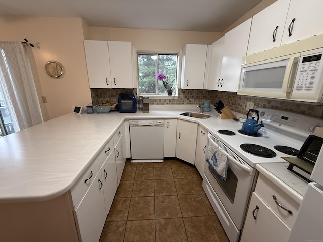 925 Oronoke Rd Unit 12G, Waterbury, CT 06708 - kitchen with white appliances, backsplash, a sink, a peninsula, and light countertops