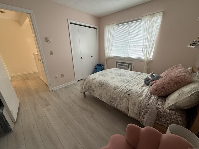 925 Oronoke Rd Unit 12G, Waterbury, CT 06708 - bedroom featuring light wood-type flooring, baseboards, a closet, and a wall unit AC