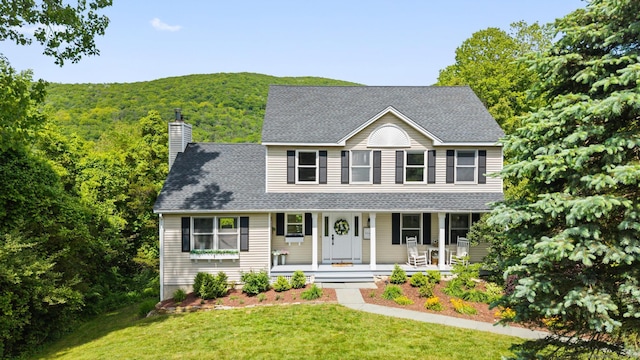 6 Lee Cir, Kent, CT 06757 - colonial-style house with a porch, a chimney, a front lawn, and roof with shingles