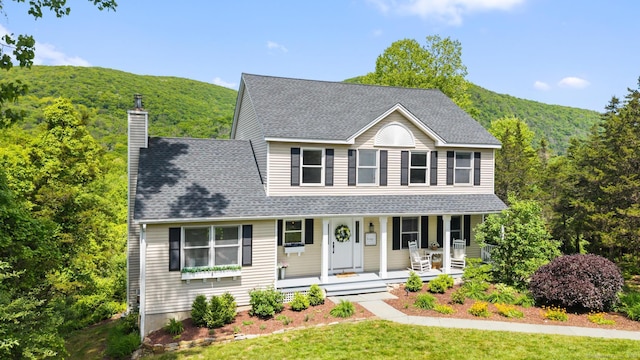 6 Lee Cir, Kent, CT 06757 - colonial inspired home featuring covered porch, a chimney, a forest view, and a front lawn
