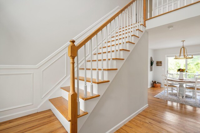 6 Lee Cir, Kent, CT 06757 - stairs featuring wood finished floors and a chandelier