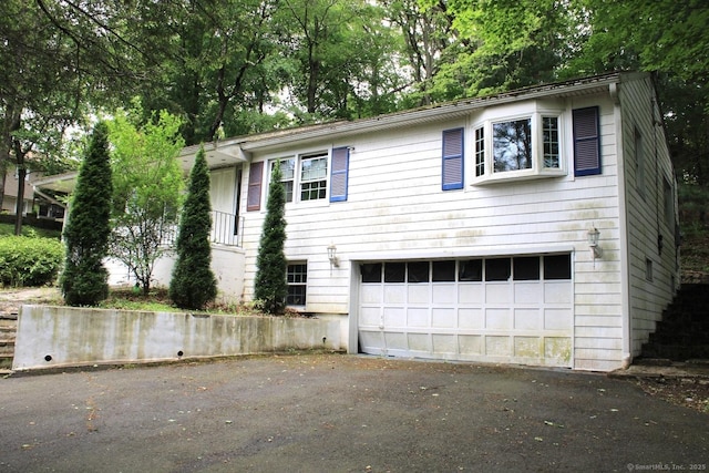 73 Devils Garden Rd, Norwalk, CT 06854 - view of front of home with driveway, a garage, and view of scattered trees