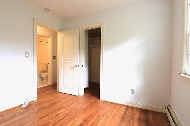73 Devils Garden Rd, Norwalk, CT 06854 - unfurnished bedroom featuring a baseboard radiator, light wood-type flooring, baseboards, and a closet