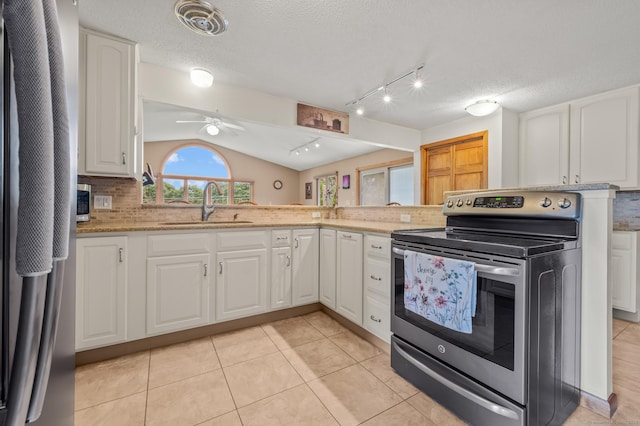 223 Beach Rd, Wolcott, CT 06716 - kitchen with stainless steel range with electric stovetop, fridge, tasteful backsplash, white cabinetry, and vaulted ceiling