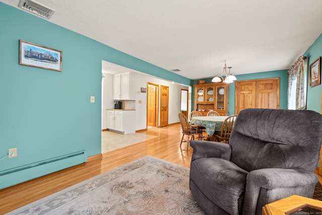 223 Beach Rd, Wolcott, CT 06716 - living room featuring a baseboard heating unit, light wood finished floors, and a chandelier