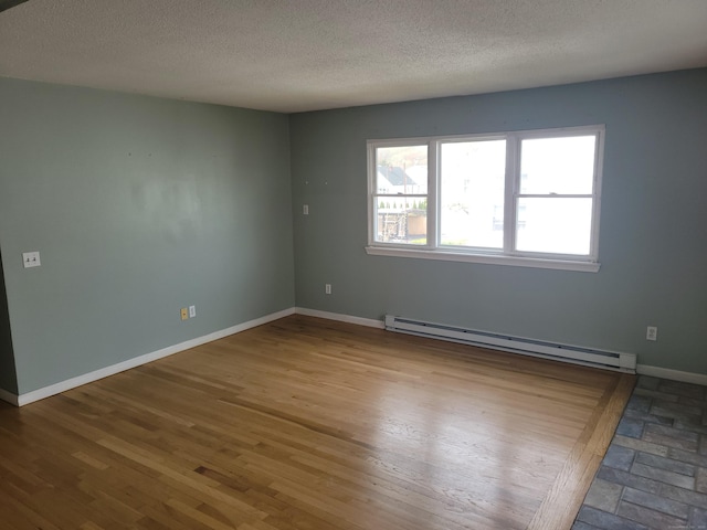 66 Macnamara St, Waterbury, CT 06708 - unfurnished room with a baseboard radiator, a textured ceiling, baseboards, and wood finished floors