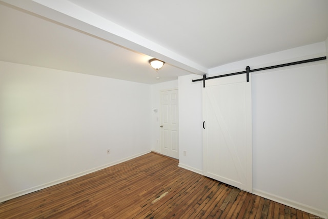 35 Church St, East Windsor, CT 06016 - unfurnished bedroom featuring a barn door, hardwood / wood-style flooring, and baseboards