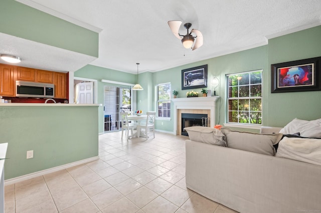31 High St Unit 10103, East Hartford, CT 06118 - living area featuring crown molding, a tile fireplace, light tile patterned floors, baseboards, and a ceiling fan