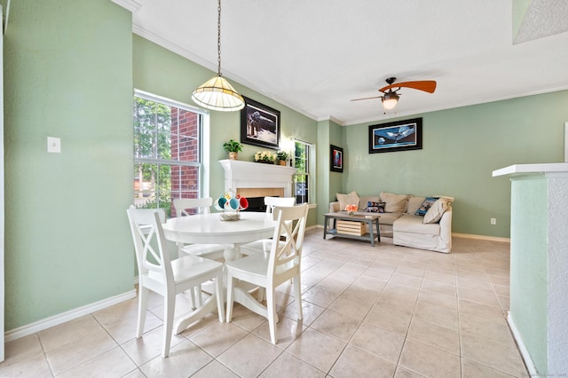31 High St Unit 10103, East Hartford, CT 06118 - dining area featuring a fireplace, crown molding, ceiling fan, light tile patterned floors, and baseboards
