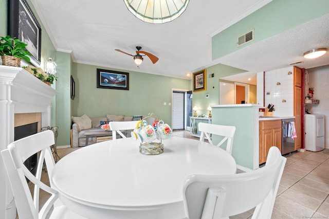 31 High St Unit 10103, East Hartford, CT 06118 - dining space featuring washer / clothes dryer, crown molding, light tile patterned floors, a fireplace, and ceiling fan