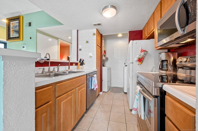 31 High St Unit 10103, East Hartford, CT 06118 - kitchen with stainless steel appliances, a sink, light countertops, light tile patterned floors, and a textured ceiling