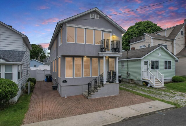 25 Milesfield Ave, Milford, CT 06460 - view of front facade with stucco siding, a patio area, and a balcony