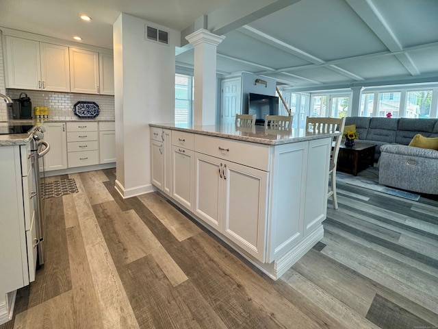 25 Milesfield Ave, Milford, CT 06460 - kitchen with wood finished floors, open floor plan, stove, white cabinetry, and decorative backsplash