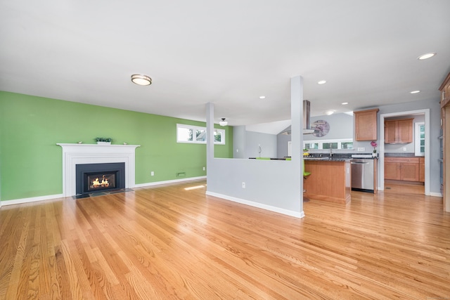 34 Fox Hill Rd, Wethersfield, CT 06109 - unfurnished living room with light wood finished floors, a fireplace with flush hearth, baseboards, recessed lighting, and a sink