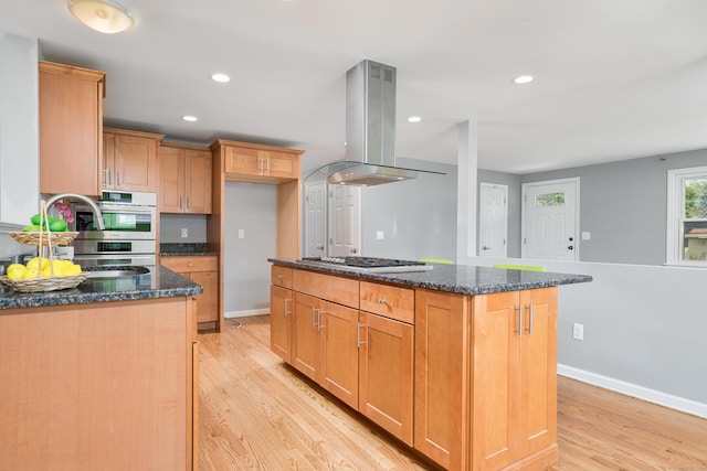 34 Fox Hill Rd, Wethersfield, CT 06109 - kitchen with island range hood, appliances with stainless steel finishes, light wood-style floors, dark stone counters, and a center island