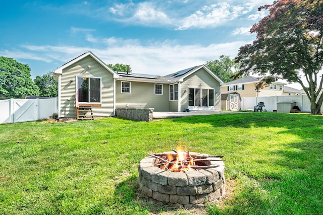 34 Fox Hill Rd, Wethersfield, CT 06109 - rear view of house featuring roof mounted solar panels, a fire pit, a gate, and a patio area
