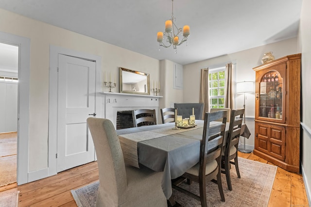 517 Wolcott Hill Rd, Wethersfield, CT 06109 - dining space featuring a chandelier, light wood-type flooring, and a fireplace