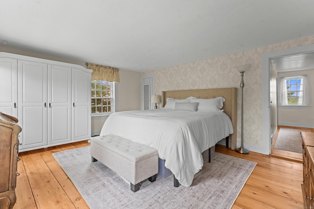 517 Wolcott Hill Rd, Wethersfield, CT 06109 - bedroom with wallpapered walls, multiple windows, light wood finished floors, and baseboards