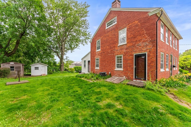 517 Wolcott Hill Rd, Wethersfield, CT 06109 - rear view of property with a chimney, brick siding, and a yard