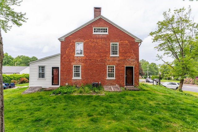 517 Wolcott Hill Rd, Wethersfield, CT 06109 - back of property with brick siding, a lawn, and a chimney