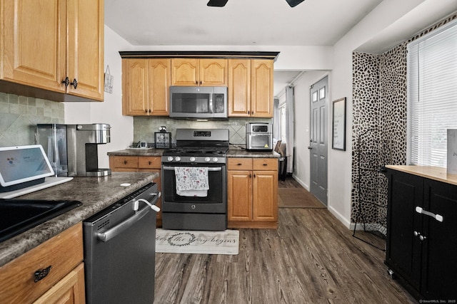 104 Bay Ave, New Britain, CT 06053 - kitchen featuring stainless steel appliances, dark wood finished floors, dark countertops, and backsplash