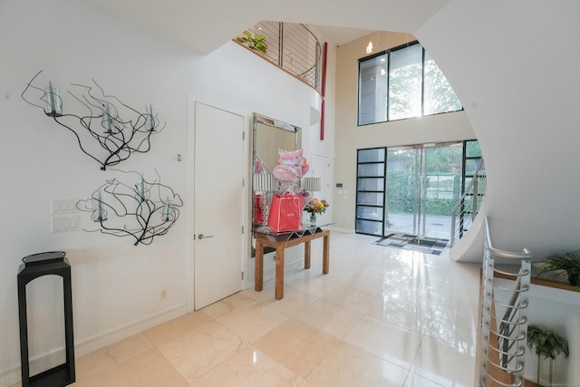 5050 Main St, Stratford, CT 06614 - foyer entrance with a high ceiling, light tile patterned flooring, and baseboards