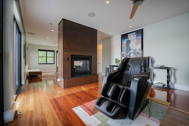5050 Main St, Stratford, CT 06614 - living area featuring a multi sided fireplace, ceiling fan, light wood-style floors, baseboards, and recessed lighting