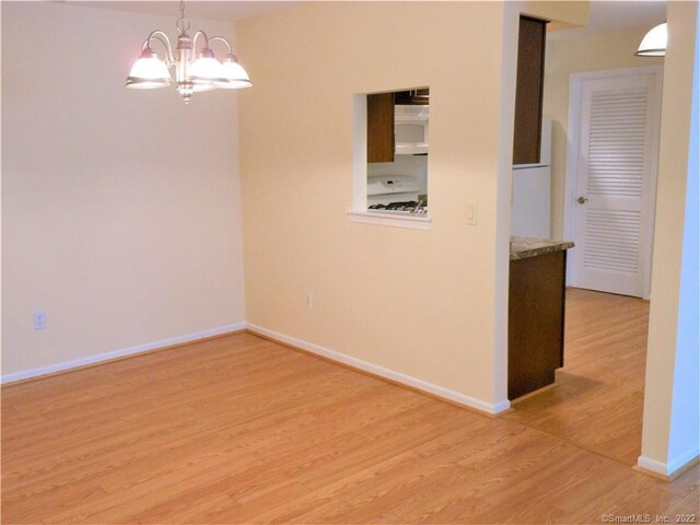18 Greenview Ln Unit 18, Milford, CT 06461 - empty room with light wood-style flooring and a chandelier