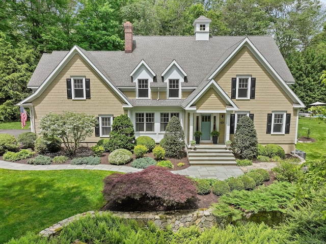 110 Florence Ln, Fairfield, CT 06824 - view of front of house featuring roof with shingles, a front yard, and a chimney