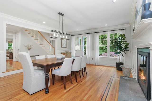 110 Florence Ln, Fairfield, CT 06824 - dining room with crown molding, stairway, a fireplace, light wood-style floors, and recessed lighting