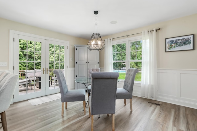 110 Florence Ln, Fairfield, CT 06824 - dining area featuring a chandelier, a decorative wall, healthy amount of natural light, light wood finished floors, and french doors