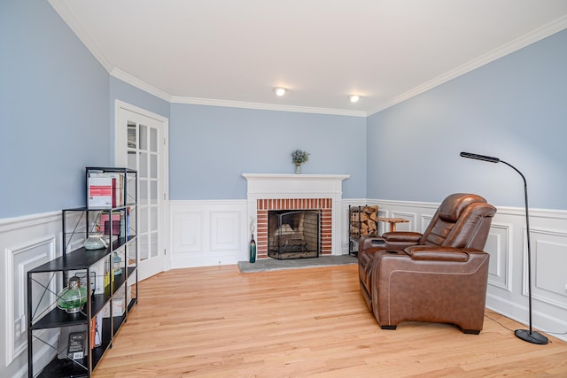 101 Railtree Hill Rd, Woodbury, CT 06798 - sitting room featuring crown molding, wood finished floors, wainscoting, a brick fireplace, and a decorative wall