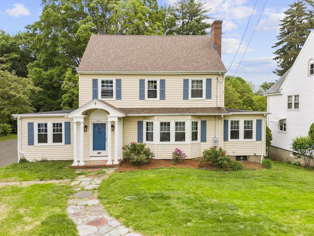1897 Stanley St, New Britain, CT 06053 - view of front of house featuring a chimney, a front yard, and a shingled roof