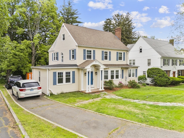 1897 Stanley St, New Britain, CT 06053 - view of front facade featuring a chimney, roof with shingles, and a front lawn
