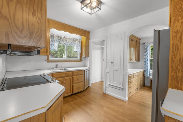 1897 Stanley St, New Britain, CT 06053 - kitchen with arched walkways, light countertops, light wood-style floors, a sink, and freestanding refrigerator