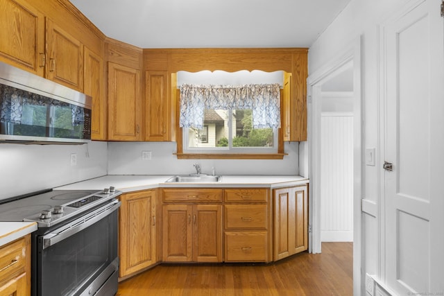 1897 Stanley St, New Britain, CT 06053 - kitchen featuring stainless steel appliances, a sink, light countertops, and wood finished floors