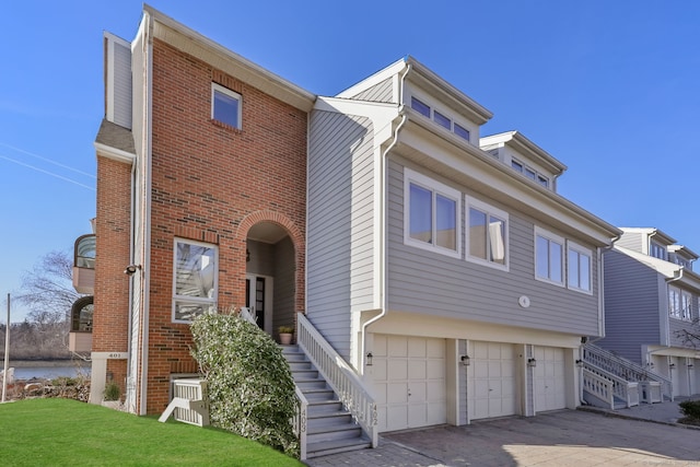 123 Harbor Dr Apt 403, Stamford, CT 06902 - townhome / multi-family property featuring an attached garage, stairs, brick siding, and a front lawn