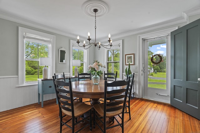 131 Elm St, Guilford, CT 06437 - dining space with a chandelier, light wood-style floors, ornamental molding, and wainscoting