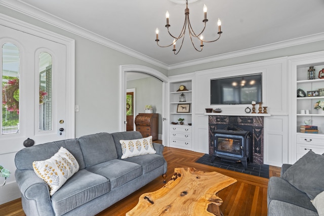 131 Elm St, Guilford, CT 06437 - living room with crown molding, a chandelier, built in features, a wood stove, and arched walkways