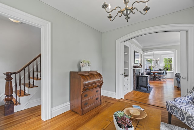 131 Elm St, Guilford, CT 06437 - living area featuring a chandelier, arched walkways, crown molding, baseboards, and stairs