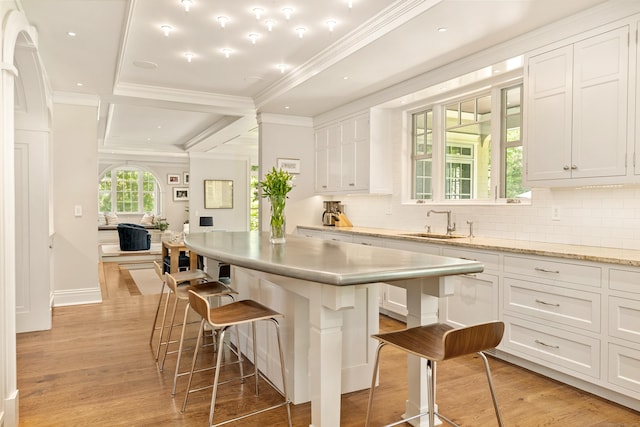 80 Compo Rd N, Westport, CT 06880 - kitchen featuring a sink, a kitchen breakfast bar, light wood-style flooring, white cabinetry, and crown molding