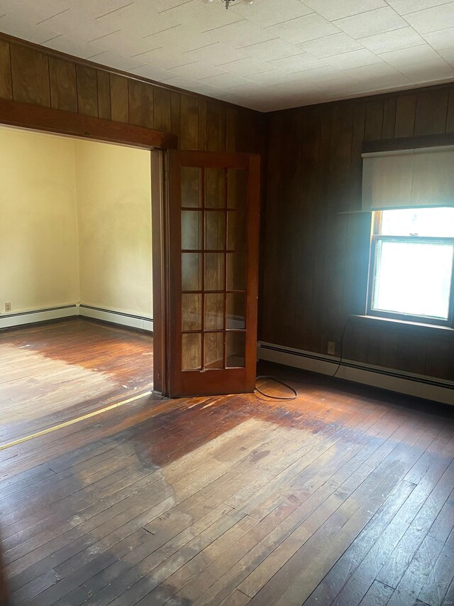 235 Long Hill Ave, Shelton, CT 06484 - unfurnished room with hardwood / wood-style flooring, baseboard heating, and wooden walls