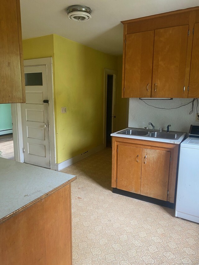 235 Long Hill Ave, Shelton, CT 06484 - kitchen with washer / dryer, a sink, brown cabinetry, and light countertops