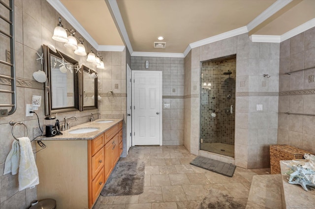 70 Birchwood Dr, Middletown, CT 06457 - bathroom featuring ornamental molding, double vanity, a tile shower, tile walls, and stone finish flooring