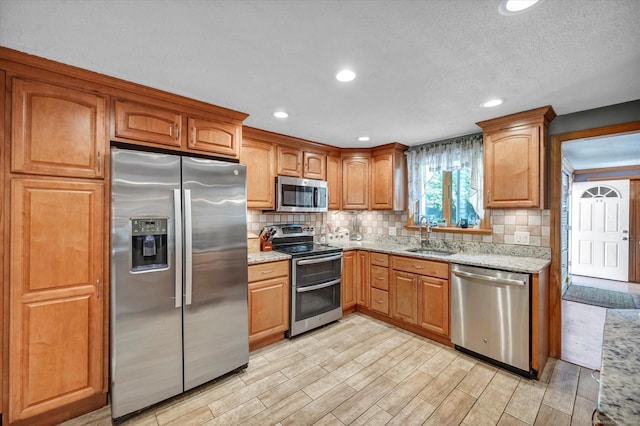 70 Birchwood Dr, Middletown, CT 06457 - kitchen featuring appliances with stainless steel finishes, a sink, backsplash, light stone counters, and recessed lighting