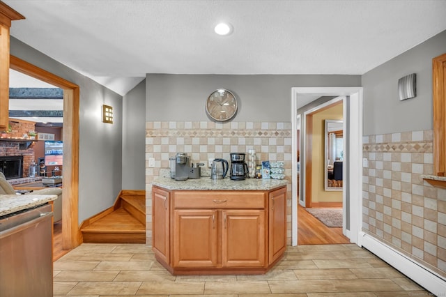 70 Birchwood Dr, Middletown, CT 06457 - kitchen featuring baseboard heating, tile walls, light stone counters, stainless steel dishwasher, and wood tiled floors