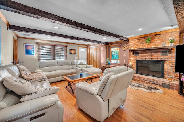 70 Birchwood Dr, Middletown, CT 06457 - living area featuring a textured ceiling, beamed ceiling, a brick fireplace, light wood finished floors, and crown molding